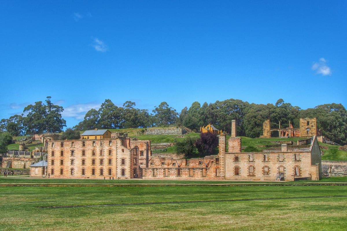 Masonry ruins of the Port Arthur penitentiary beside still harbour water